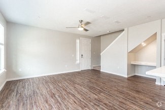 an empty living room with white walls and a ceiling fan