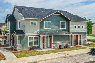 a blue house with a gray roof and a sidewalk