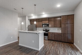 an empty kitchen with wooden floors and wooden cabinets