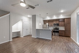 an empty living room and kitchen with wood flooring
