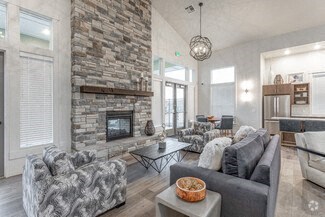 a living room with a stone fireplace and furniture