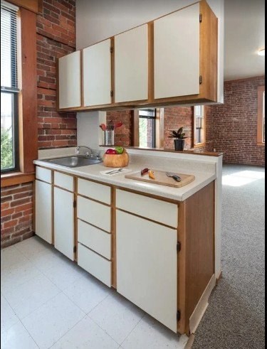 A kitchen with white cabinets and a wooden island.