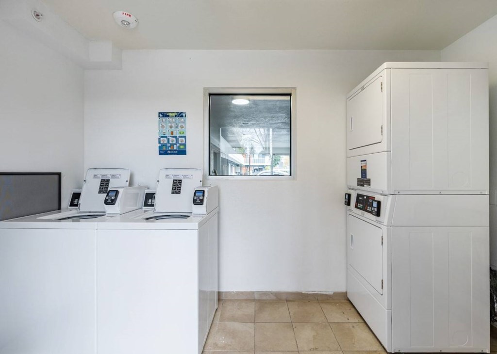 A white kitchen with a refrigerator, oven, and microwave.