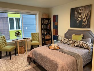 a bedroom with a bed and a desk and a painting of a zebra