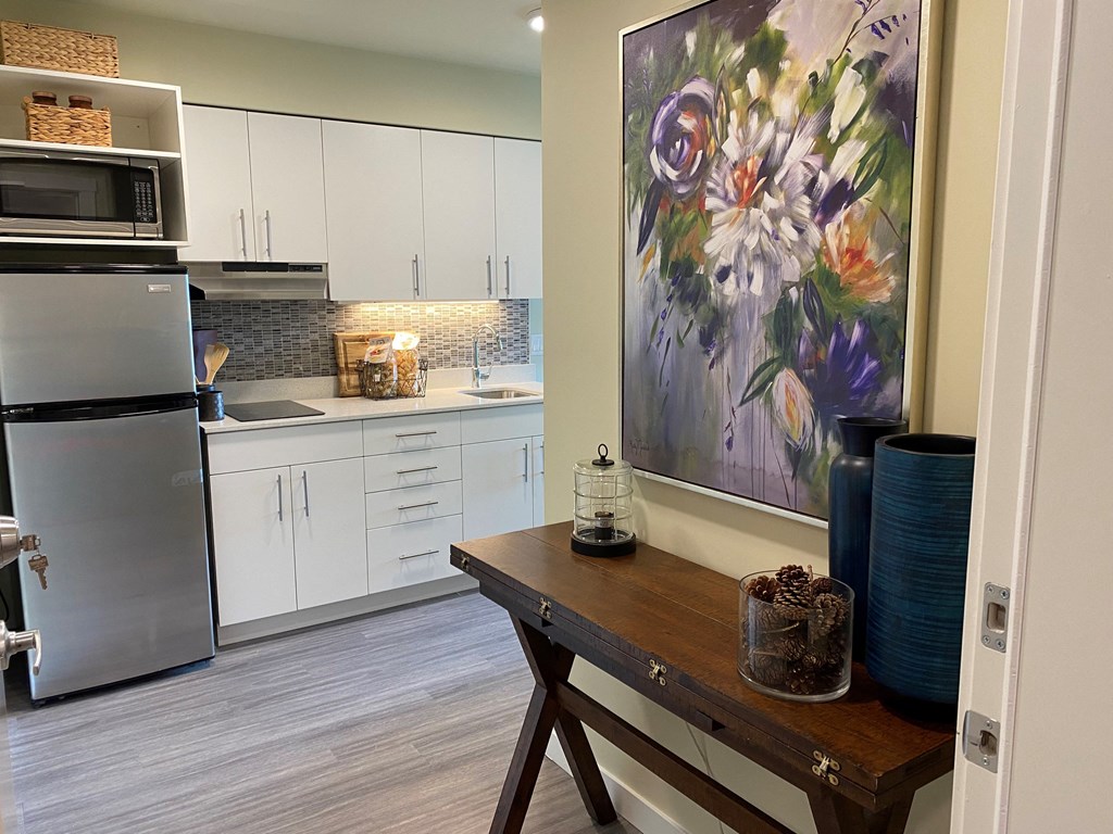 a kitchen with white cabinets and stainless steel appliances and a table