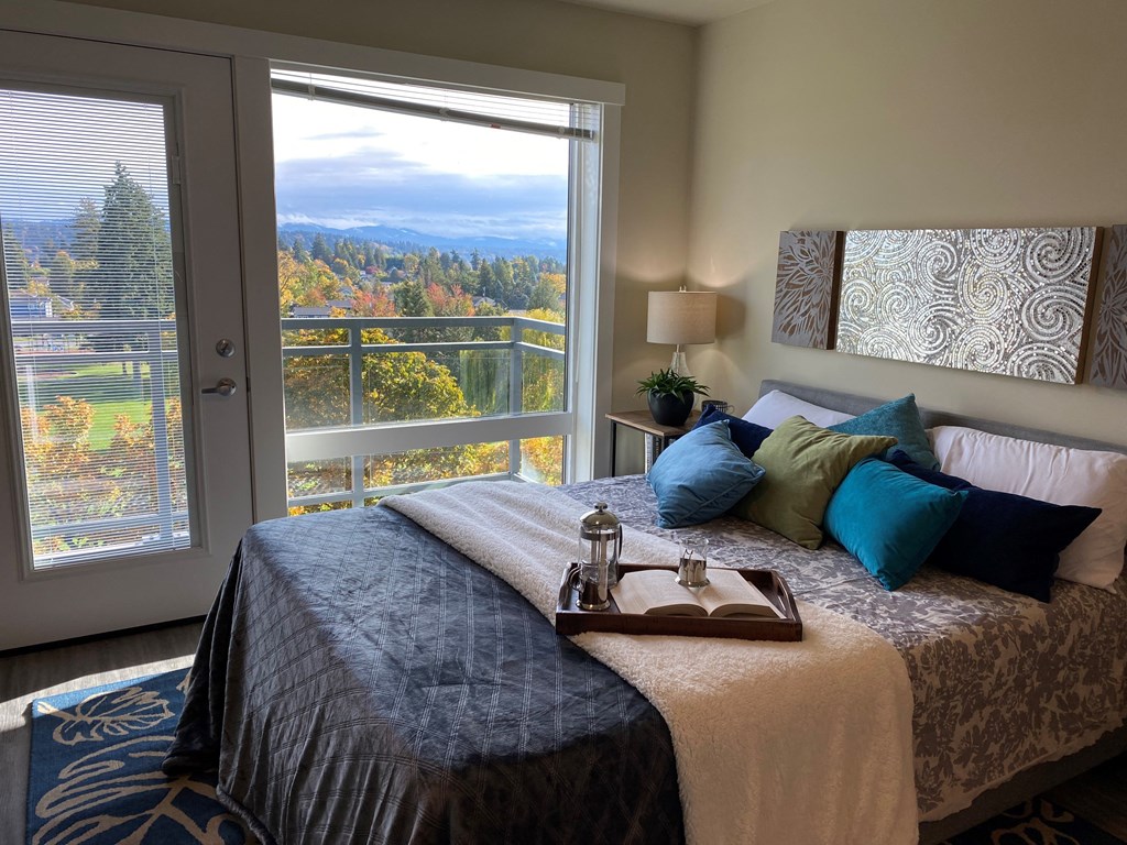 a bedroom with a view of the mountains and a bed with blue pillows