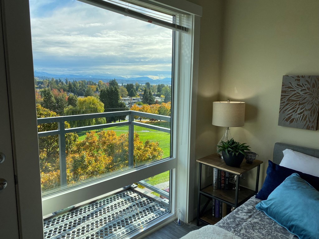a bedroom with a large window and a view of the mountains