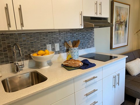 a kitchen counter with a sink and a bowl of fruit