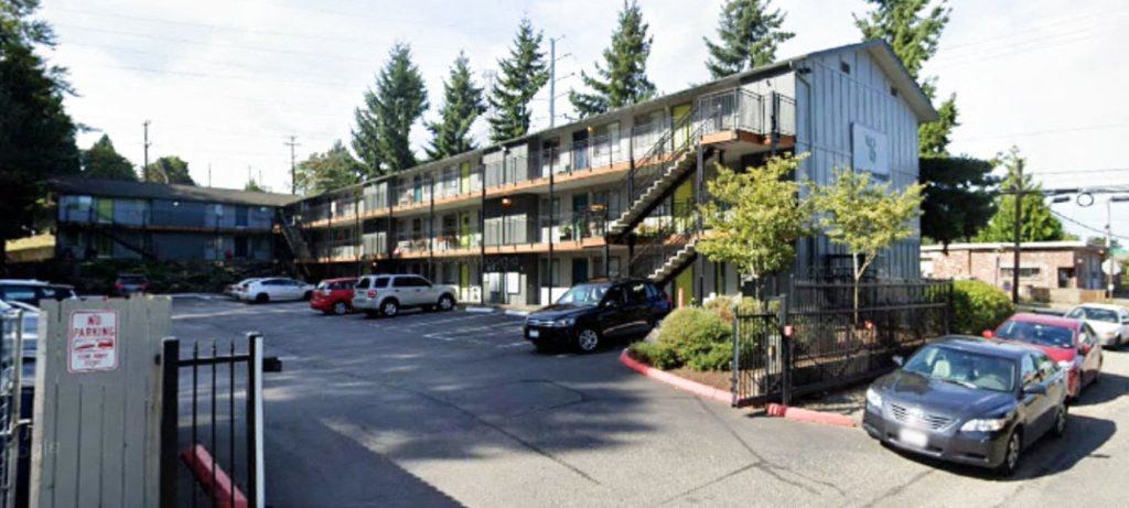 A parking lot with cars and a building in the background.