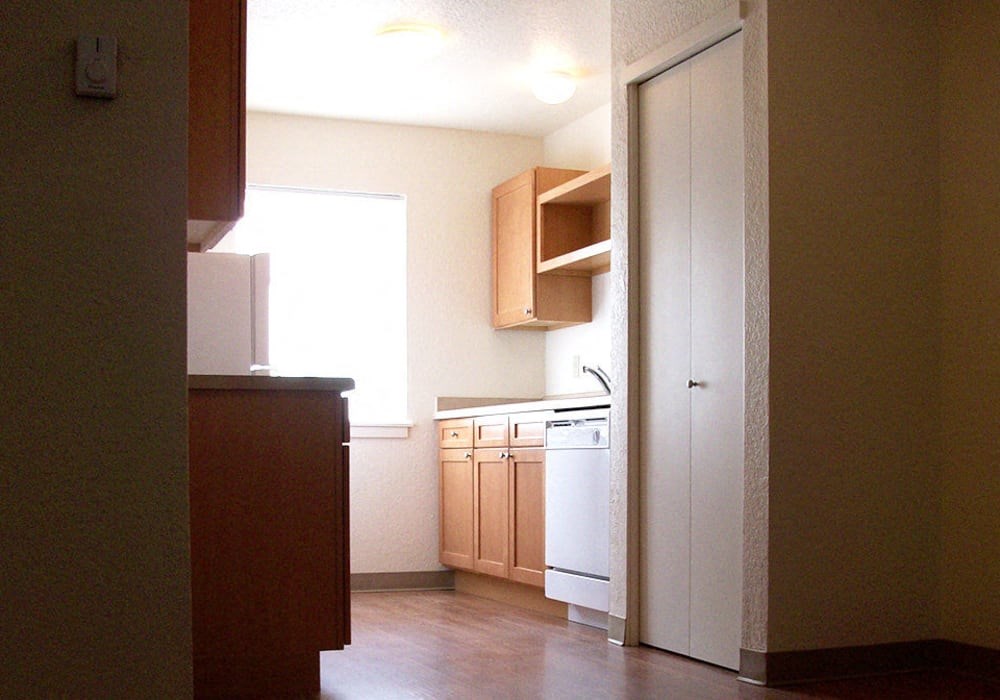 A kitchen with a white fridge and wooden cabinets.