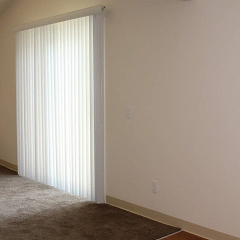 a living room with a window and a carpet