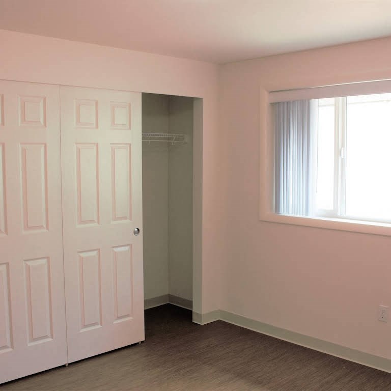 a room with a door and a window and a closet