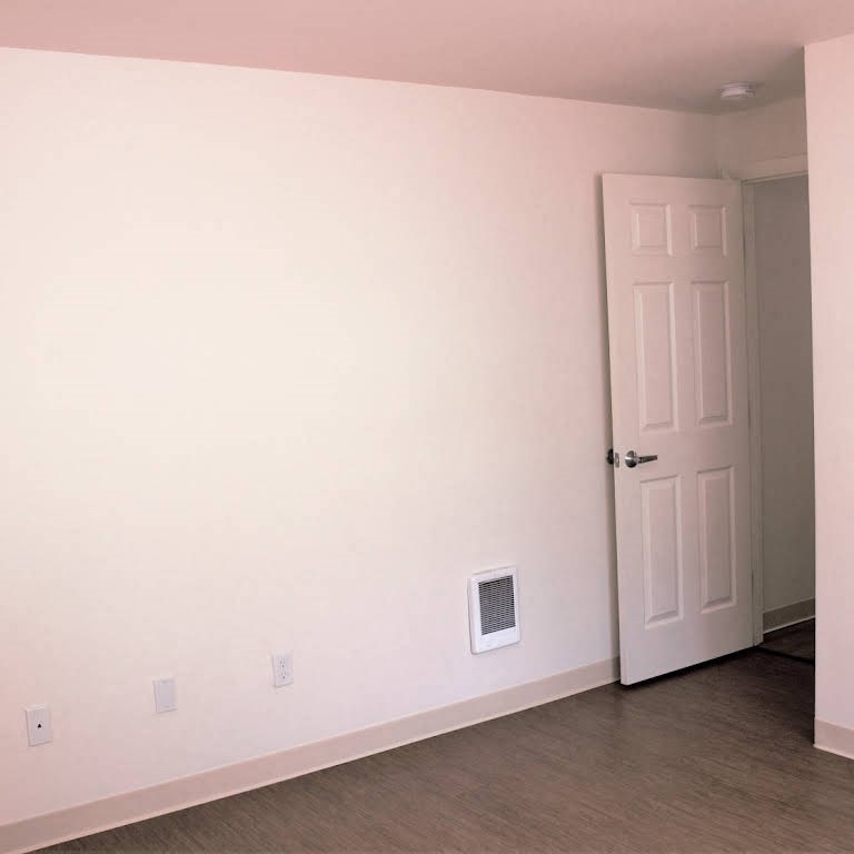 an empty room with a door and a white wall