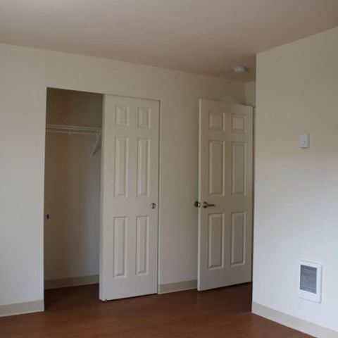 an empty room with two doors and a closet