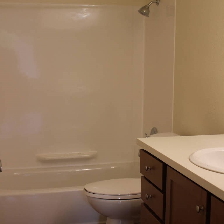 a bathroom with a toilet and a tub and a sink