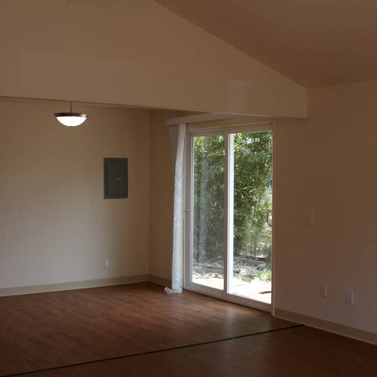 an empty living room with a sliding glass door