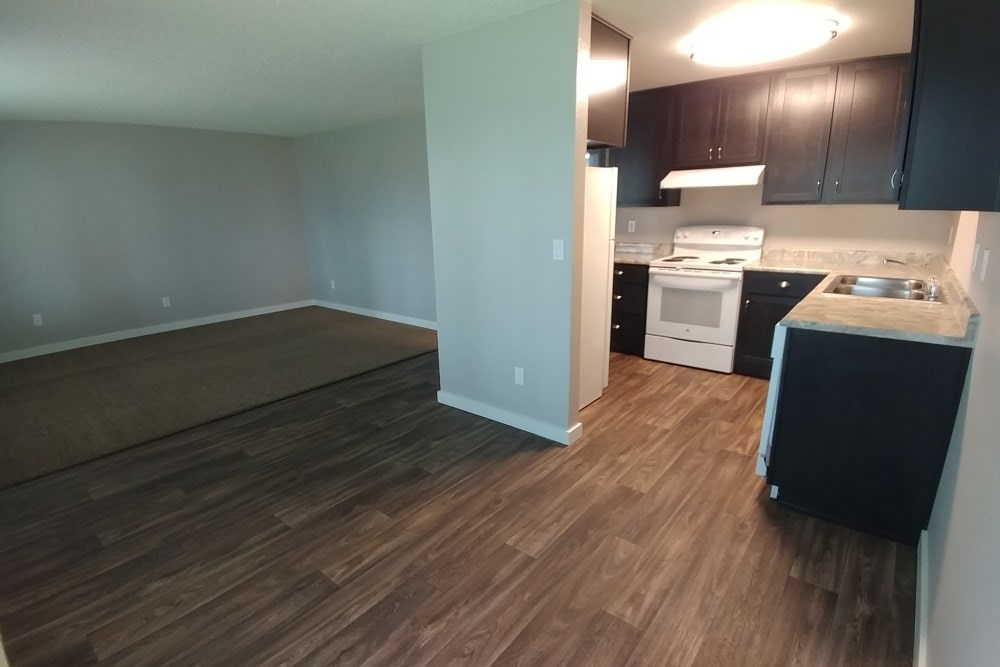A kitchen with a white stove top oven and black cabinets.