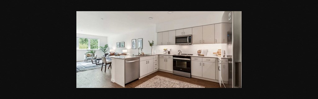 a view of a kitchen with white cabinets and a table