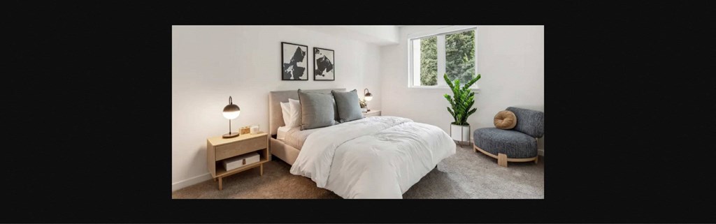 a bedroom with a bed and a chair and a window