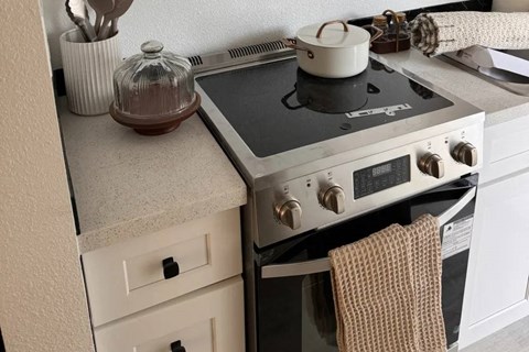 A pot sits on a stove with a towel hanging on the handle.