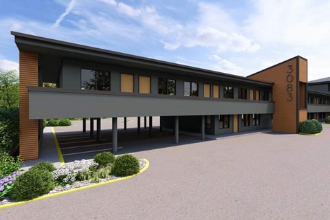 A modern building with a curved entrance and a yellow line on the ground.