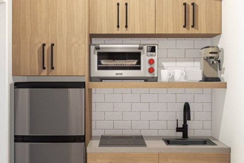 A kitchen with a black fridge, a toaster oven, and a coffee maker.