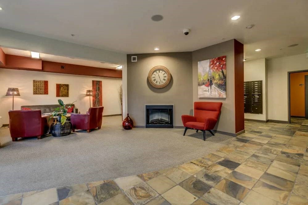 A living room with a fireplace and a clock on the wall.
