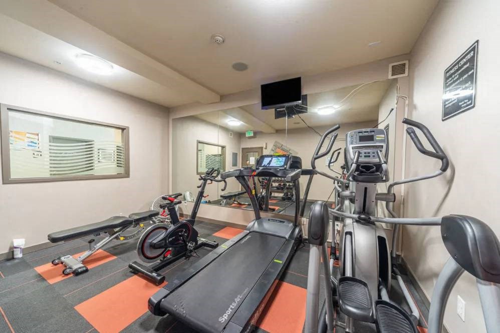 A gym with treadmills, exercise bikes, and elliptical machines.