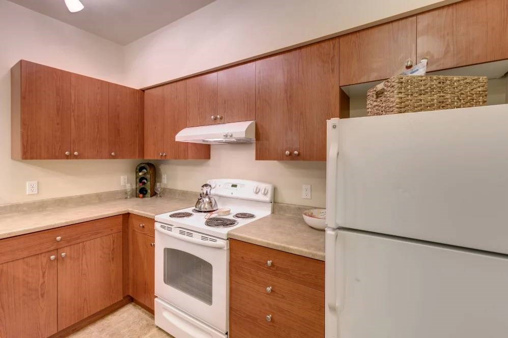 A kitchen with a white stove and refrigerator.
