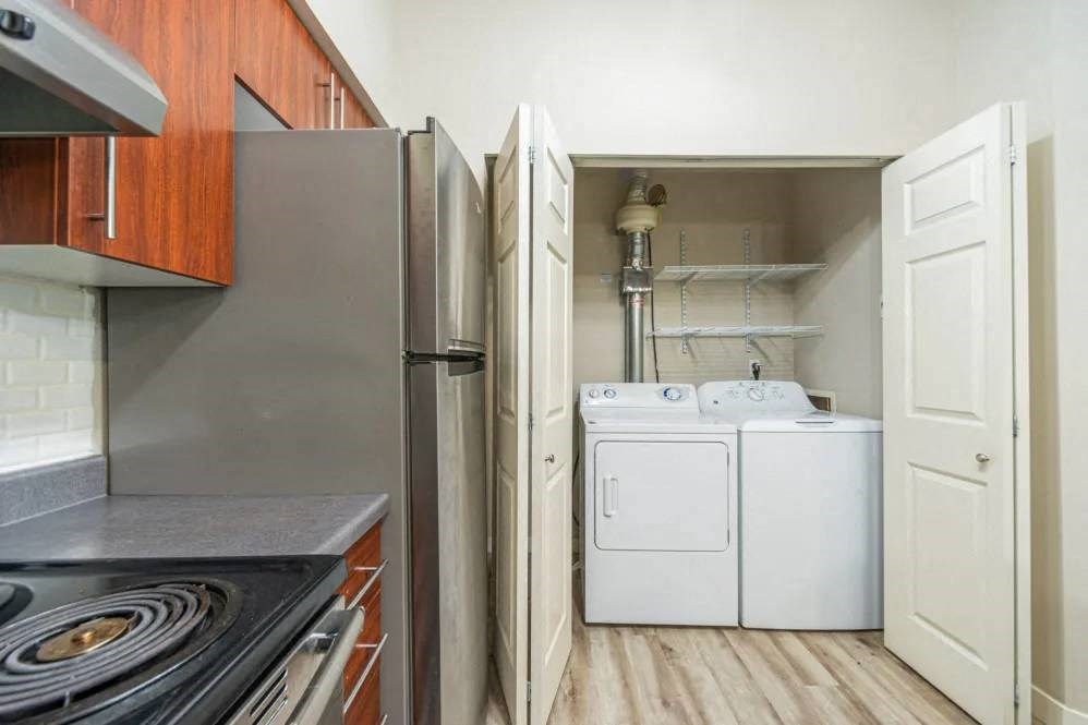 A kitchen with a stove top oven and a refrigerator.
