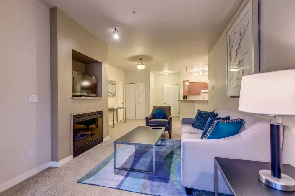 A modern living room with a fireplace and a white couch.