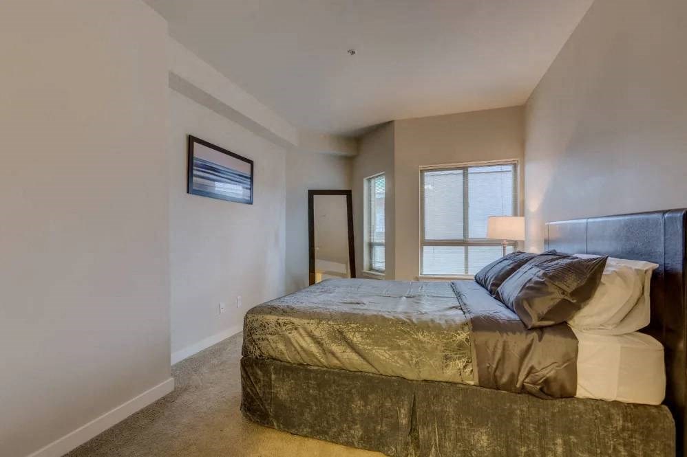A bedroom with a large bed and a painting on the wall.