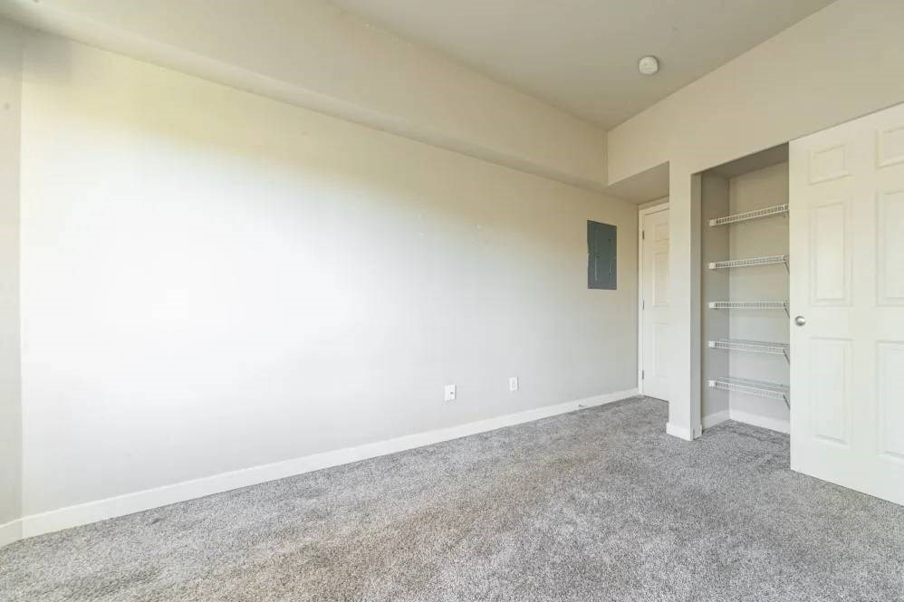 A room with a carpeted floor and a white door.