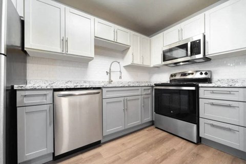 A modern kitchen with stainless steel appliances and white cabinets.
