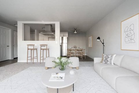 A white living room with a couch, table, and chairs.