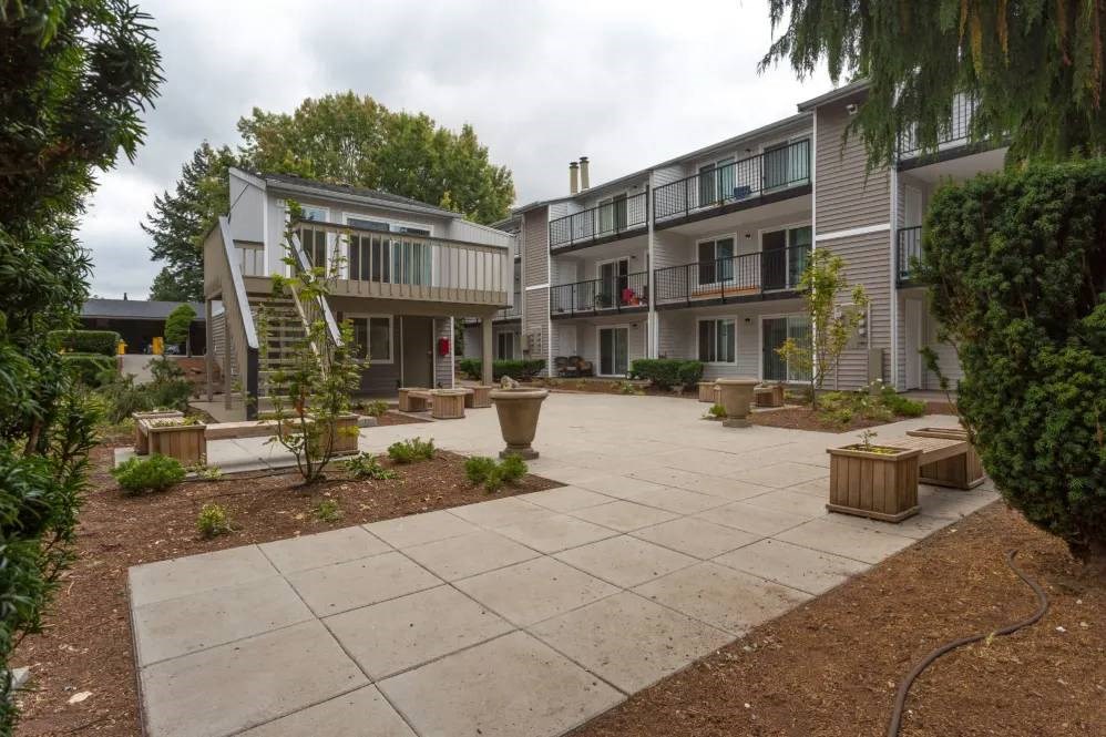 A courtyard with a concrete floor and a building in the background.