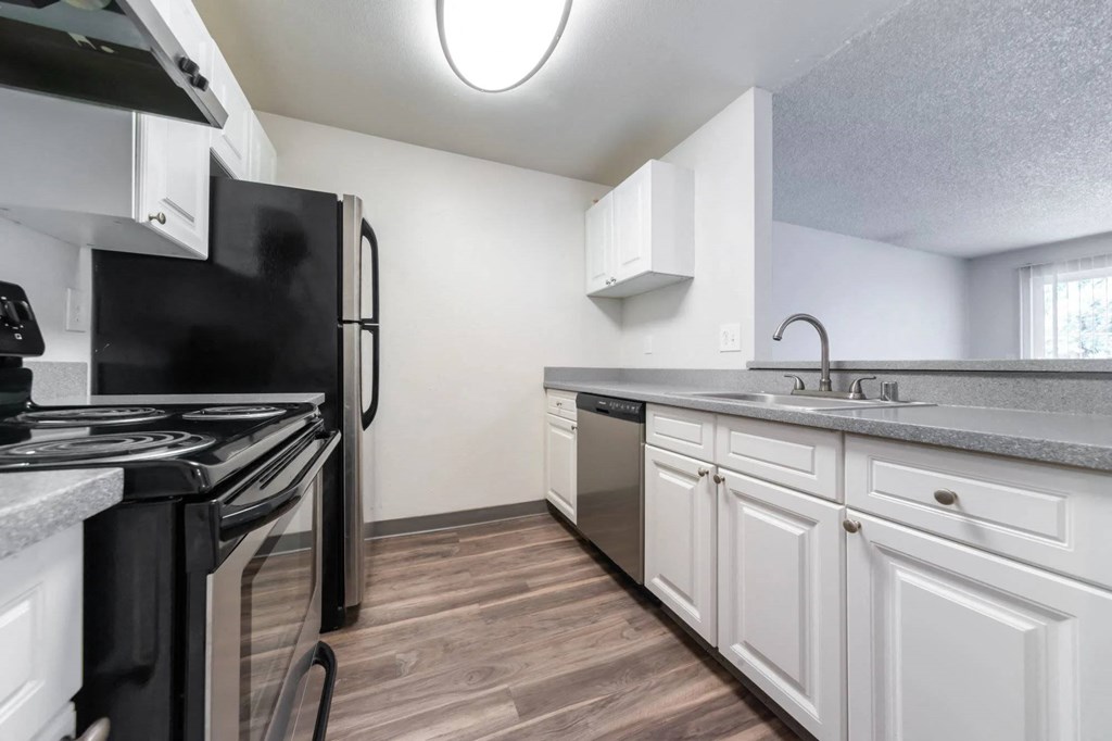 A kitchen with black appliances and white cabinets.