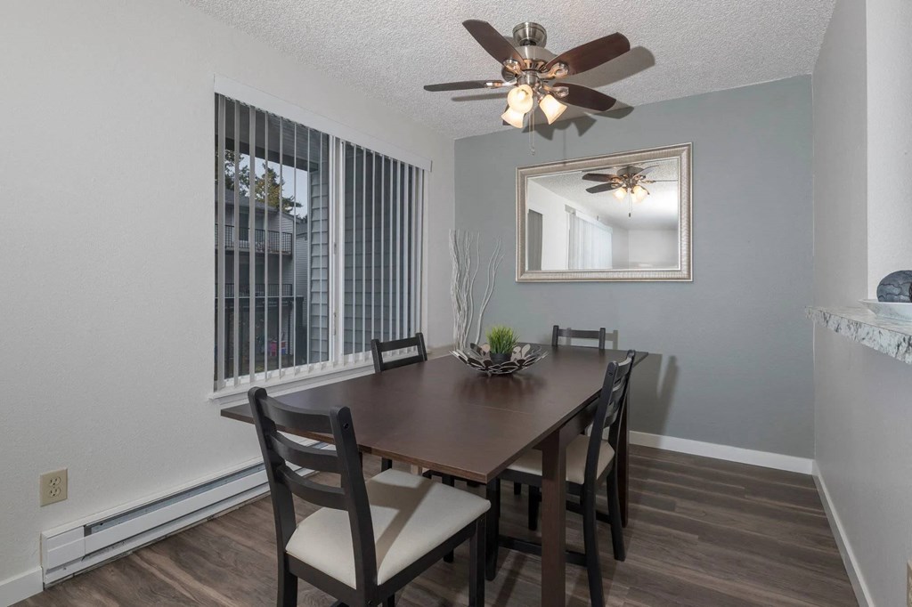 A dining room with a wooden table and chairs.