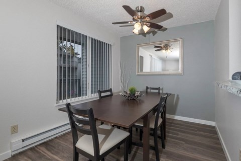 A dining room with a wooden table and chairs.