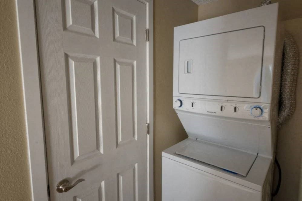 A white door is next to a white wall-mounted oven.