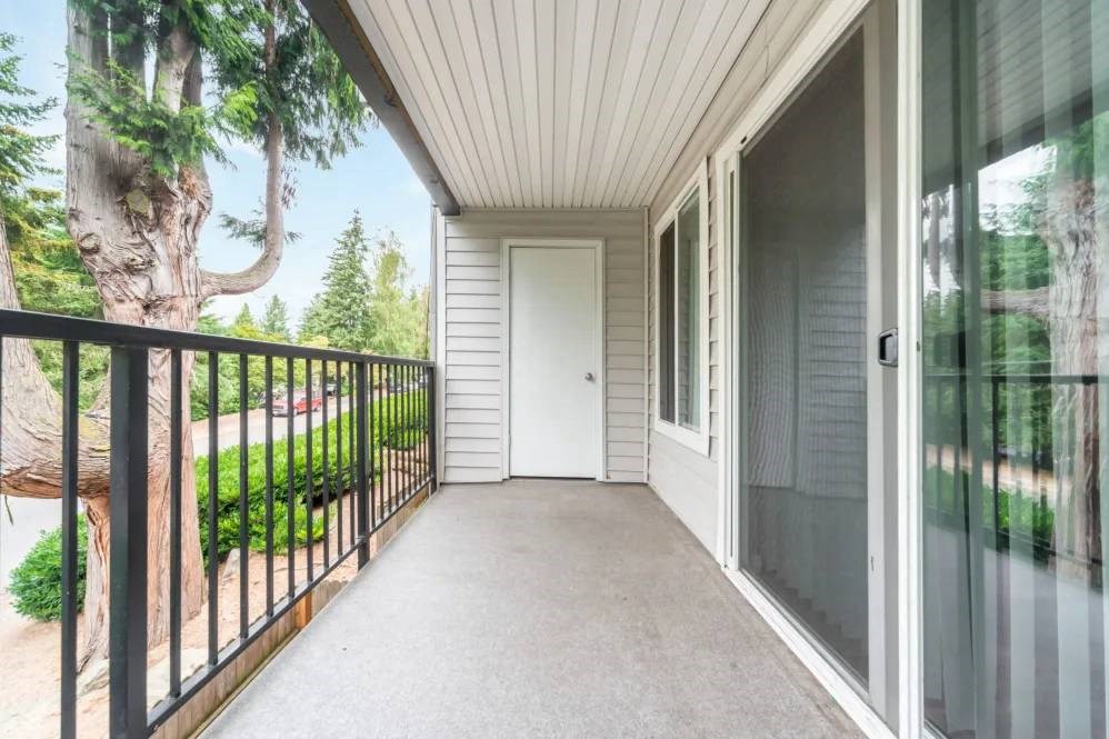 A balcony with a black railing and a white door.