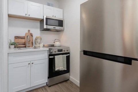 A kitchen with a stainless steel refrigerator, oven, and microwave.