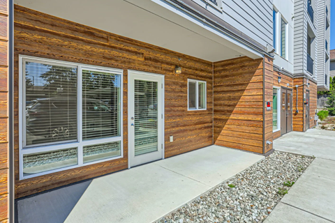 A modern house with a wooden exterior and glass windows.