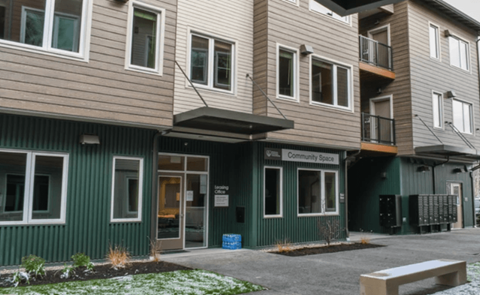 A building with a green sign that says Community Space.