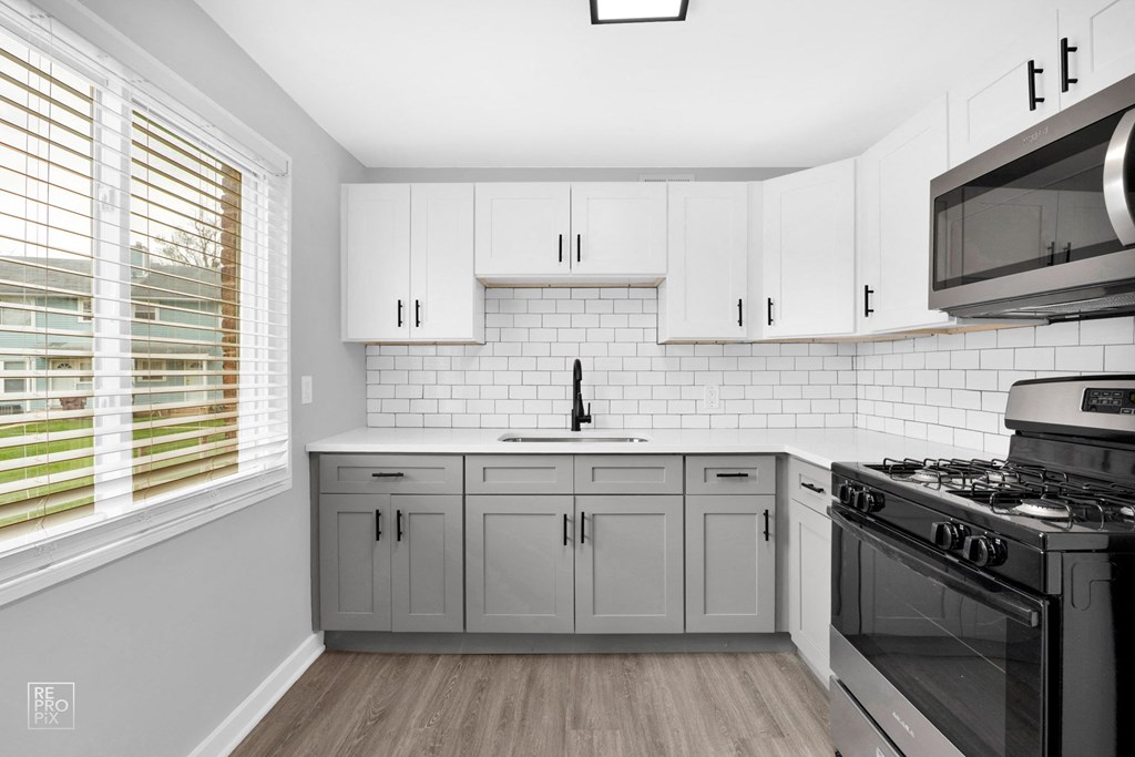 a kitchen with white cabinets and a black stove