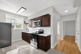 a kitchen with dark wood cabinets and a white tile floor