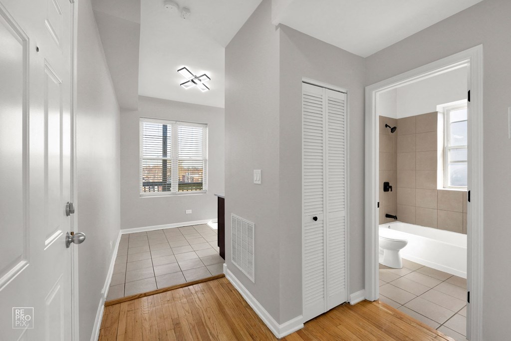 a bedroom and bathroom with a tiled floor and white walls