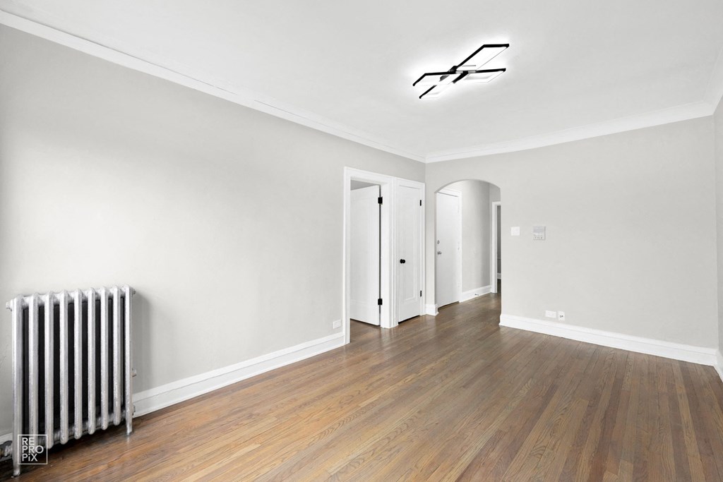a bedroom with hardwood floors and grey walls