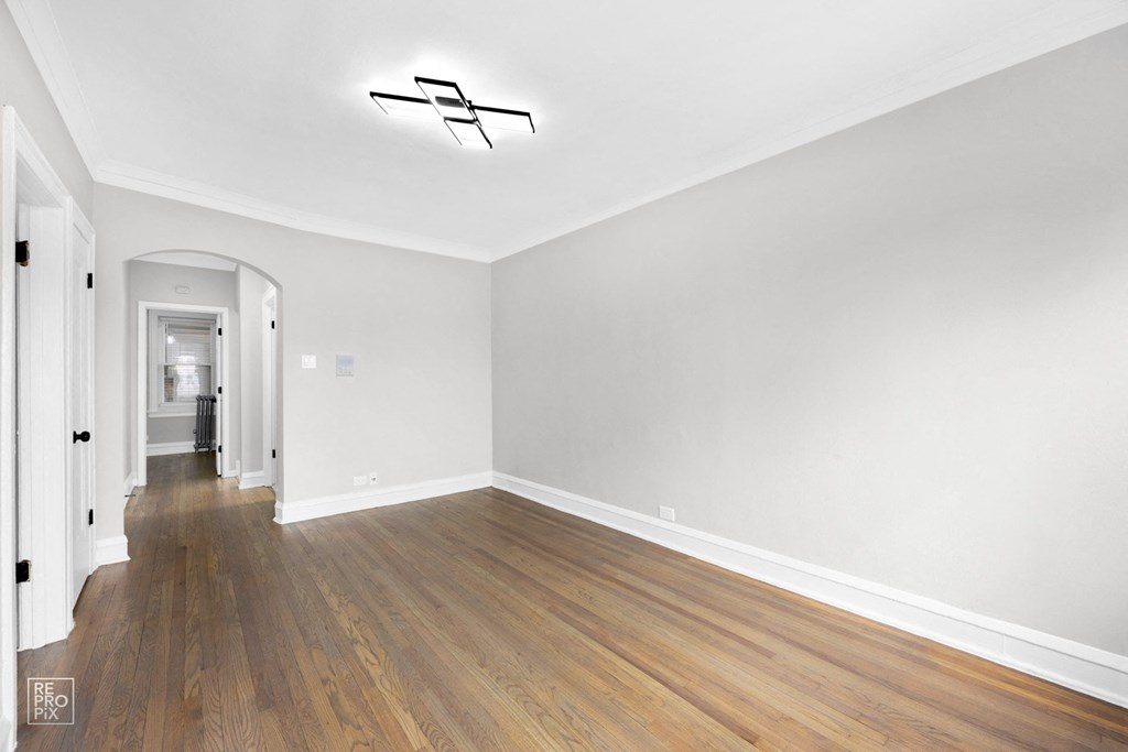 a bedroom with hardwood floors and grey walls
