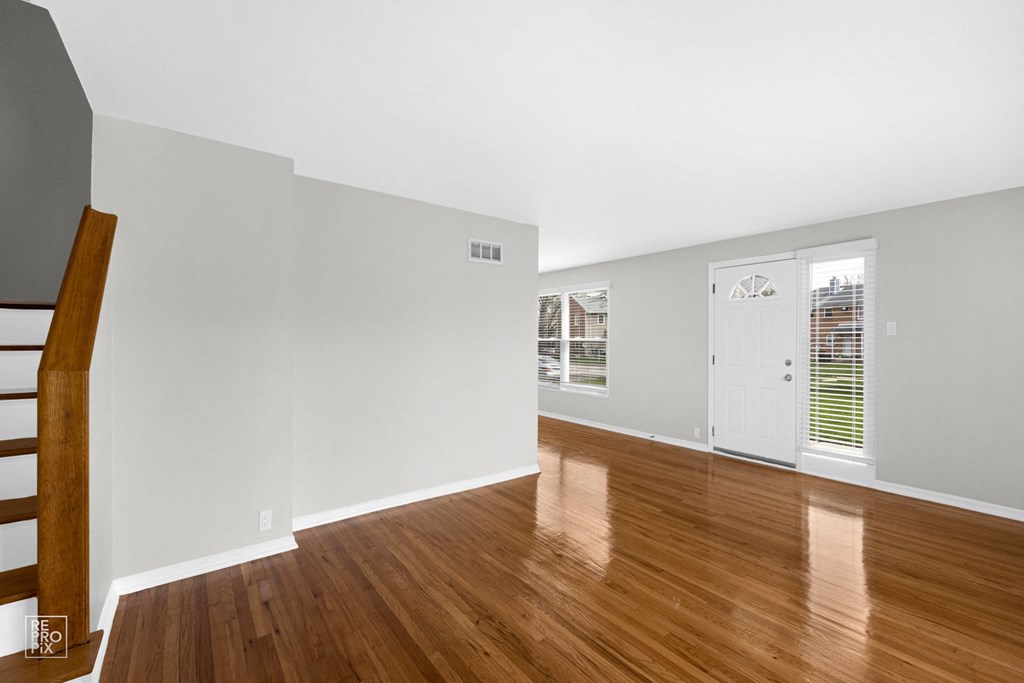 a bedroom with hardwood floors and grey walls